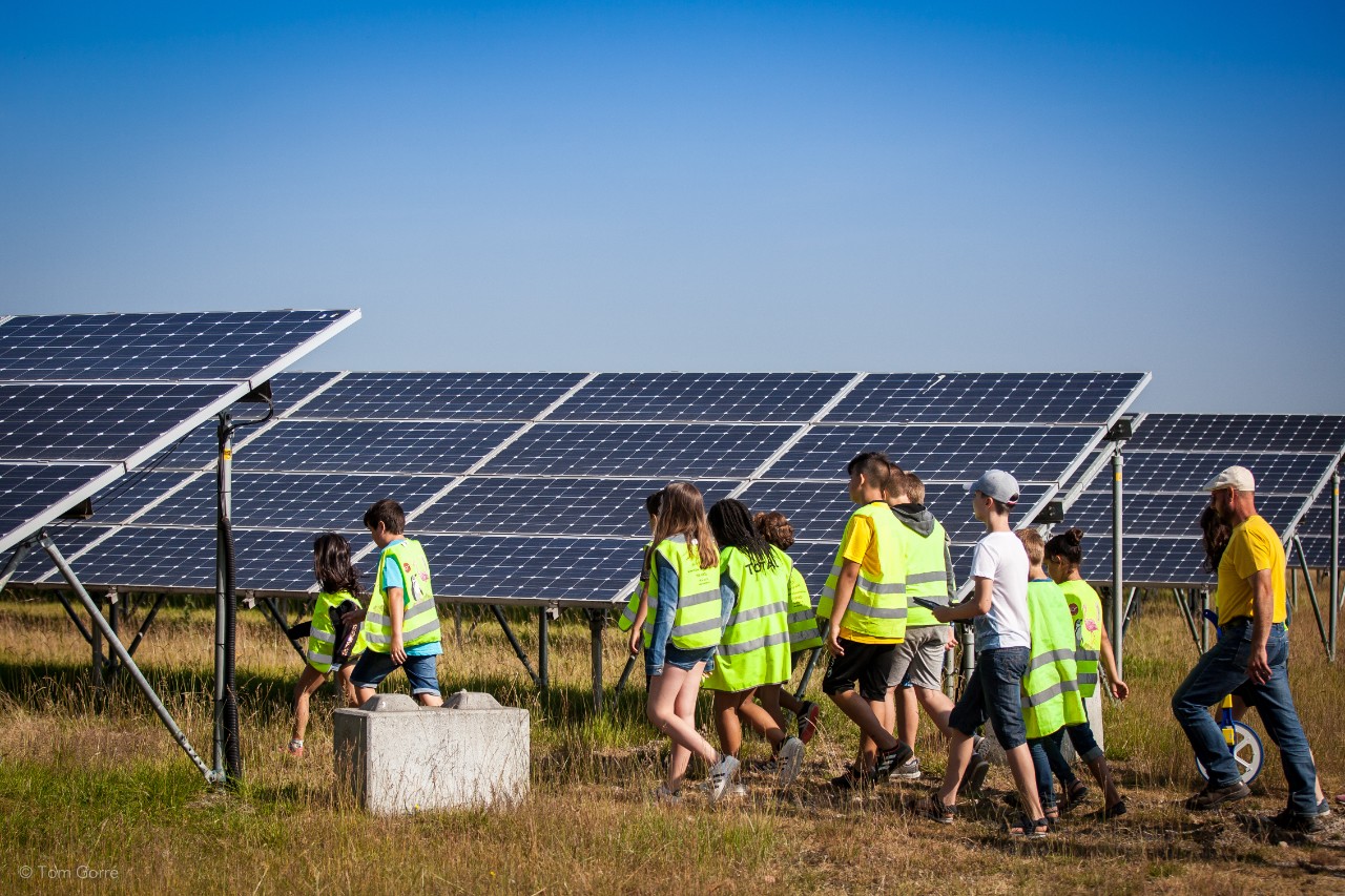 groep wandelt tussen de zonnepanelen op de zonneberg
