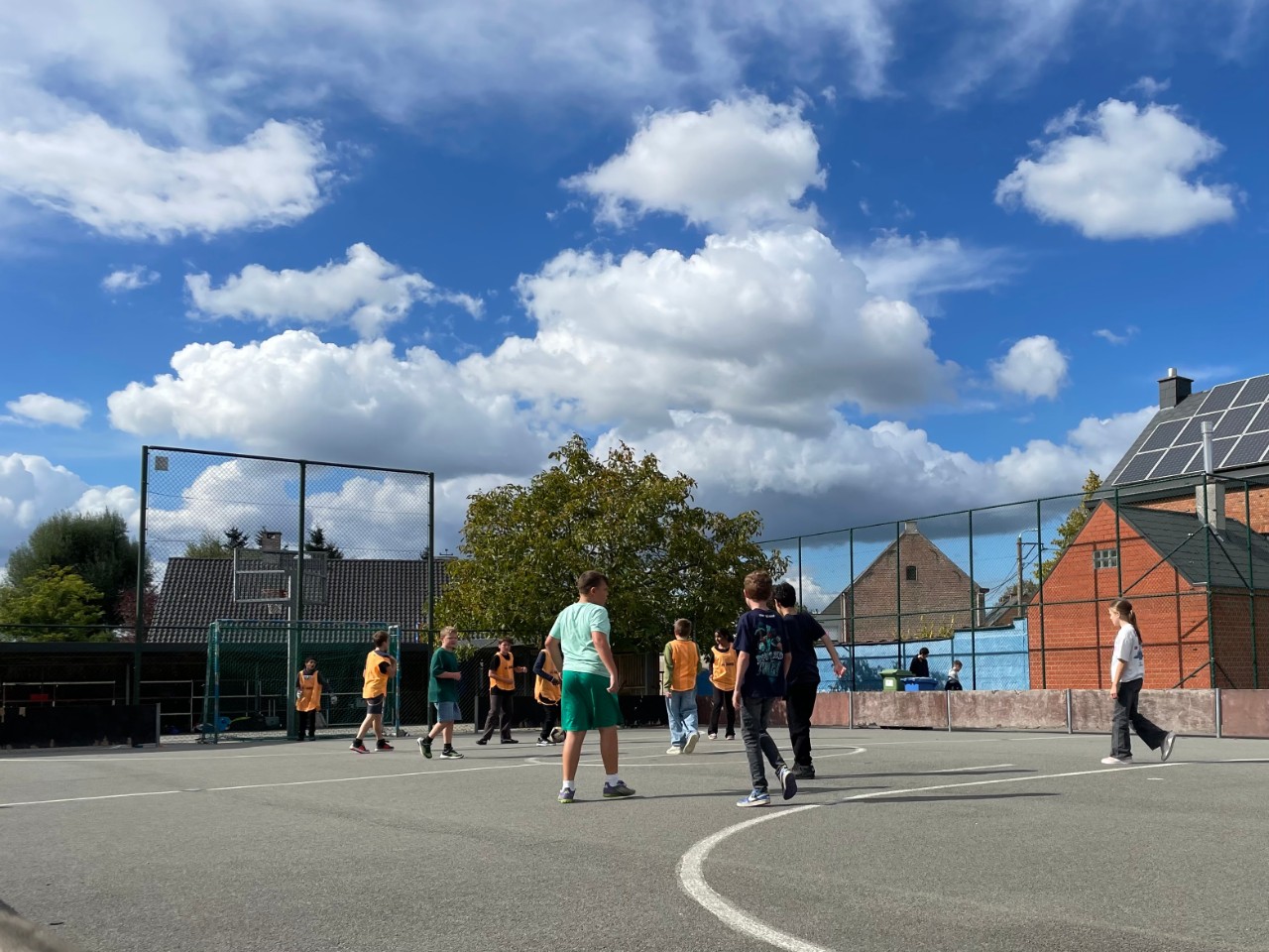 Leerlingen voetballen op de blauwe speelplaats van Kiempunt campus Buggenhout