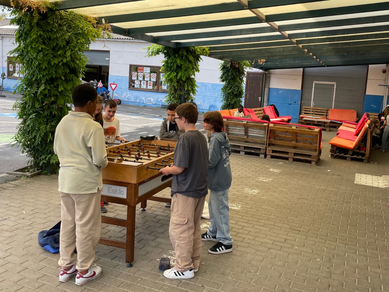 Blauwe speelplaats van Kiempunt campus Buggenhout met kinderen aan kickertafel