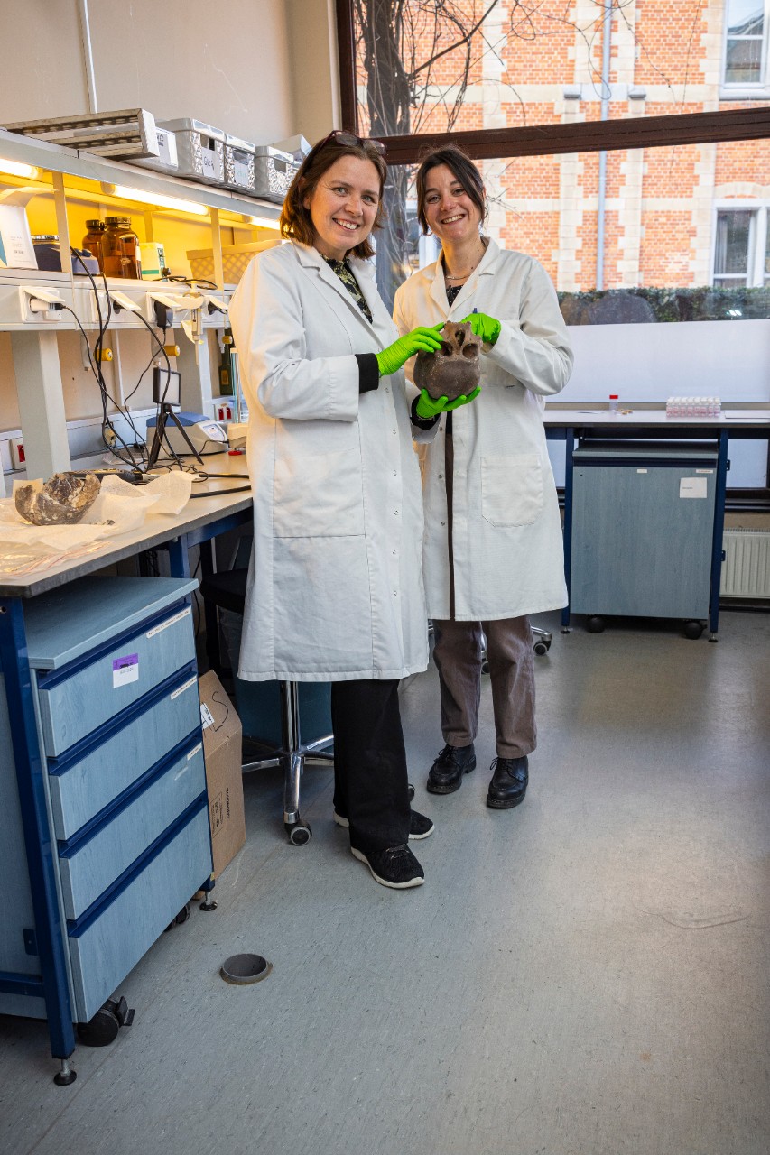 twee wetenschappers houden een schedel vast