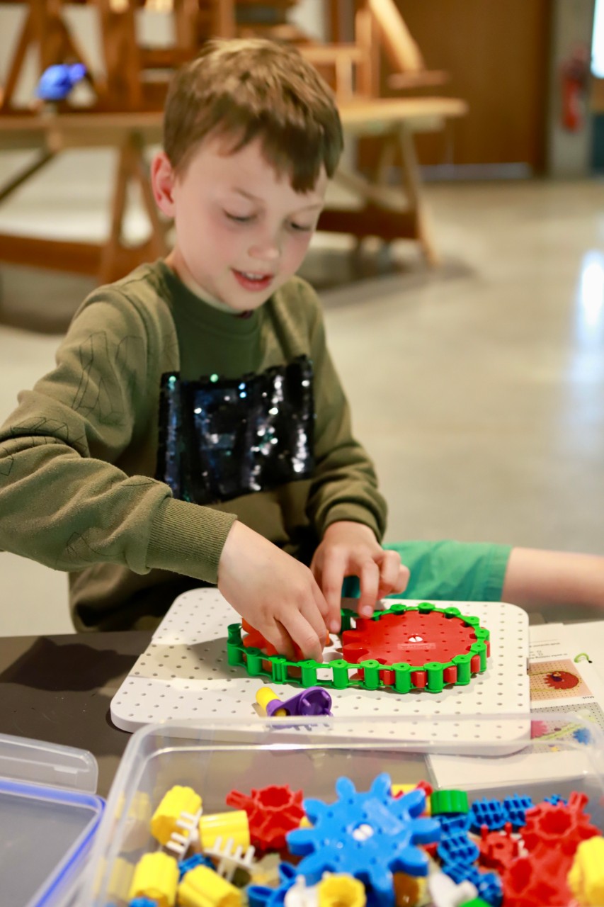 kind maakt ketting rond tandwielen