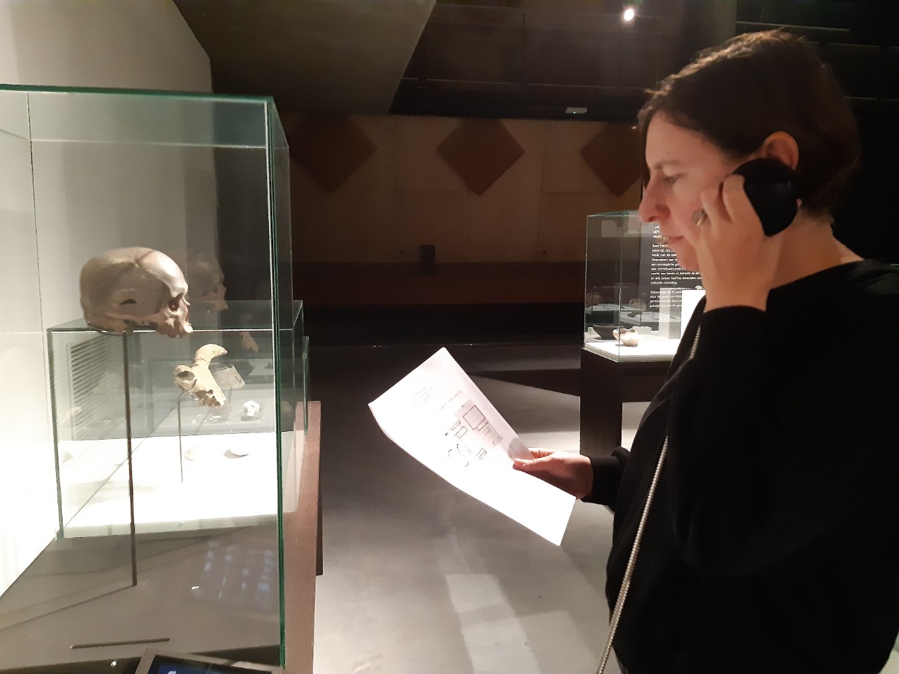 vrouw luistert naar transcriptie van item in tentoonstelling