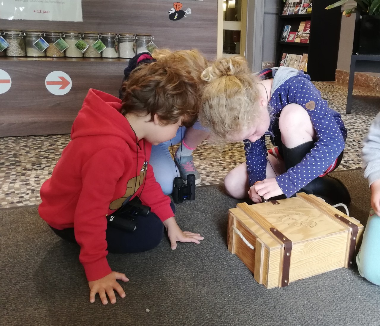 kinderen proberen een doos te openen in het mola molencentrum