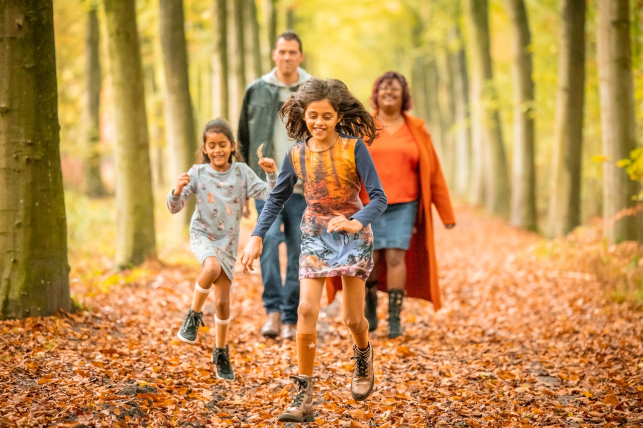 kinderen en volwassenen in het bos tijdens de herfst