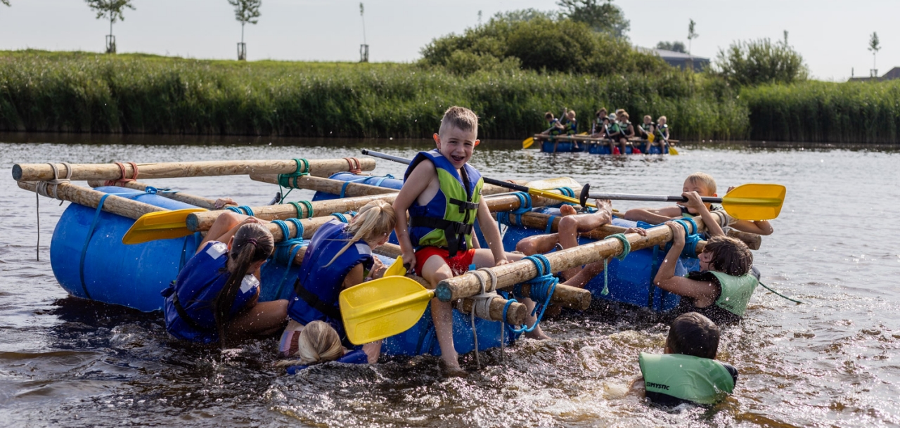 kinderen op een vlot tijdens een kamp in de boerekreek