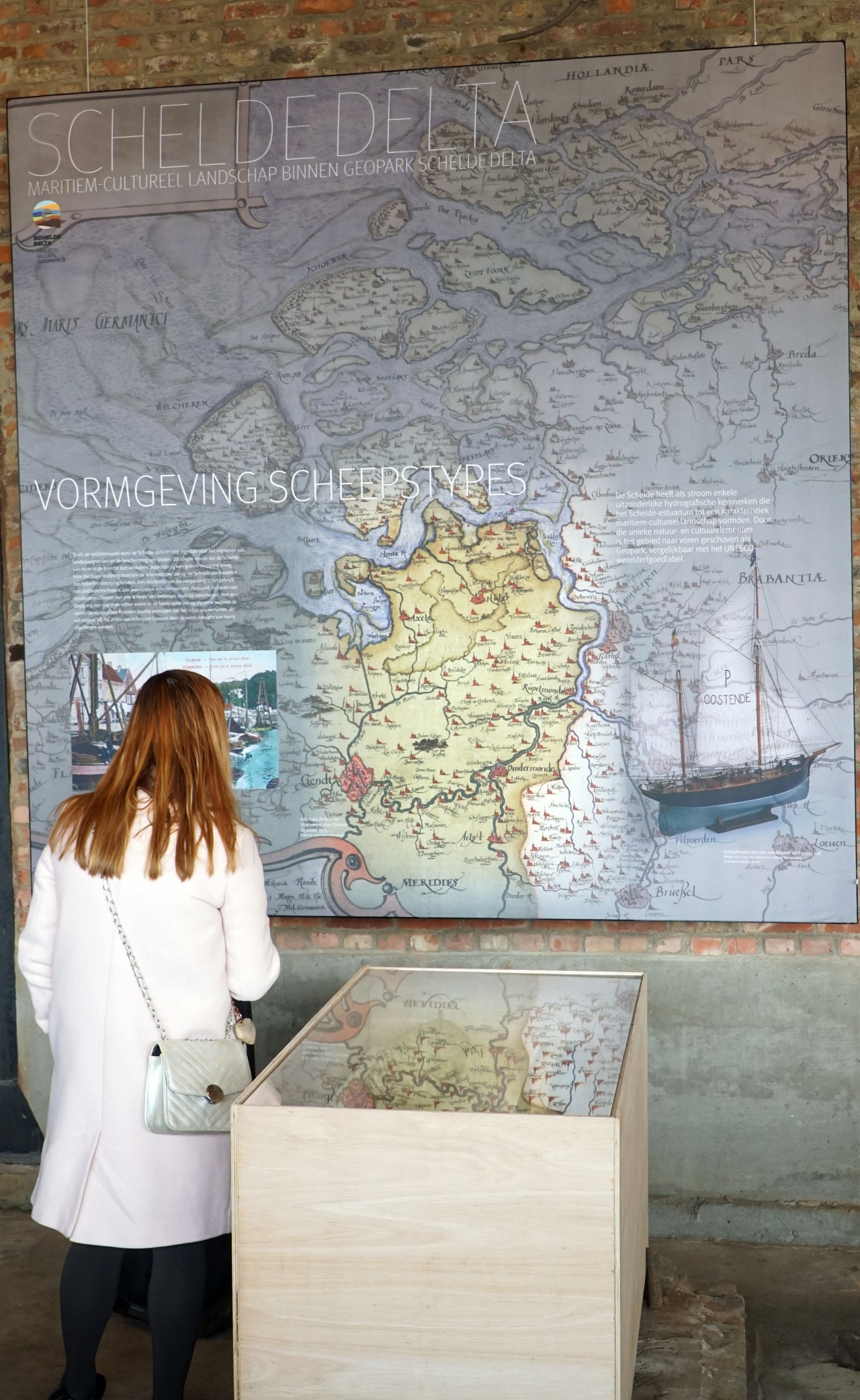 bezoeker kijkt op kaart in de tentoonstelling